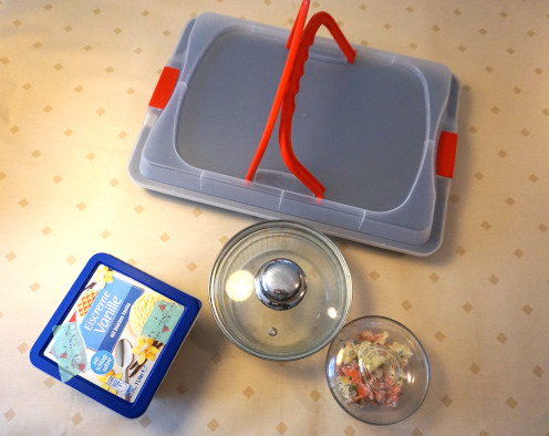 Gefäße zum Aufbewahren von Lebensmitteln: Backblech mit einer Haube, leere Eiskiste, eine Glasschale mit passendem Deckel, eine Glasschale abgedeckt mit einem Teller